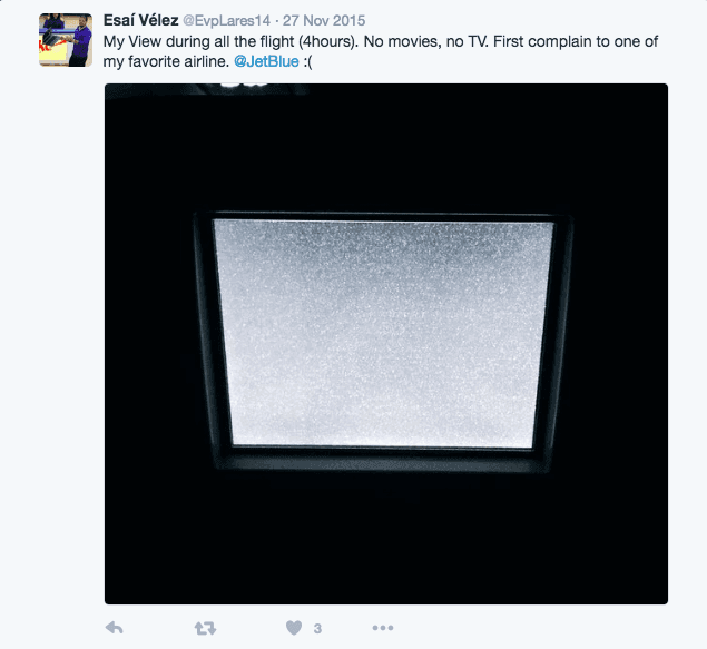 Tweet complaining about a blank, static airplane TV screen, tagged to JetBlue Airways