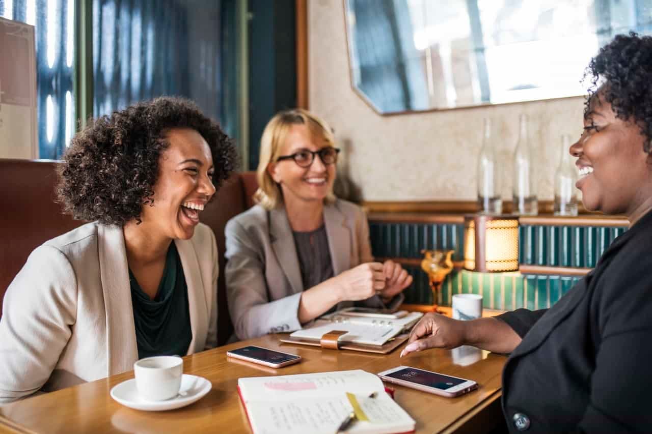 Team members laughing together in business meeting around table with materials