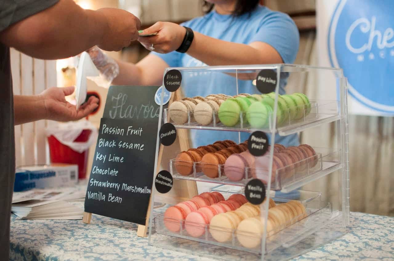 Customer at bakery counter purchasing macarons