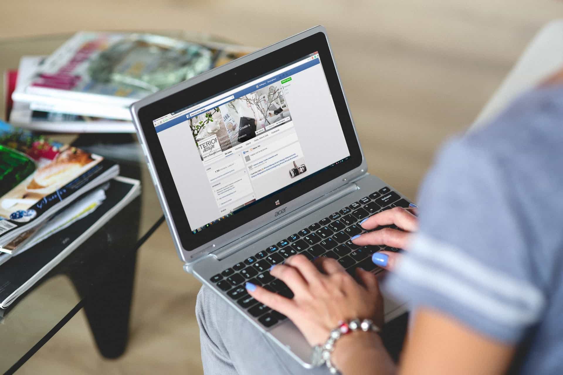 Woman using laptop to manage Facebook business page