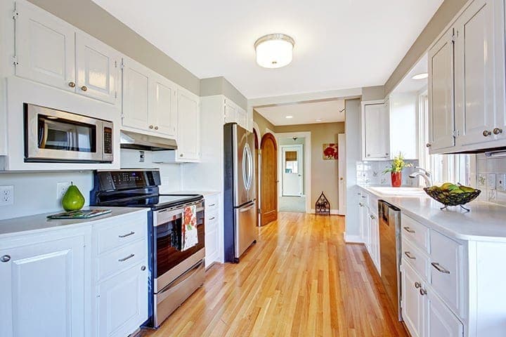 Clean, bright kitchen with white cabinetry and stainless steel appliances