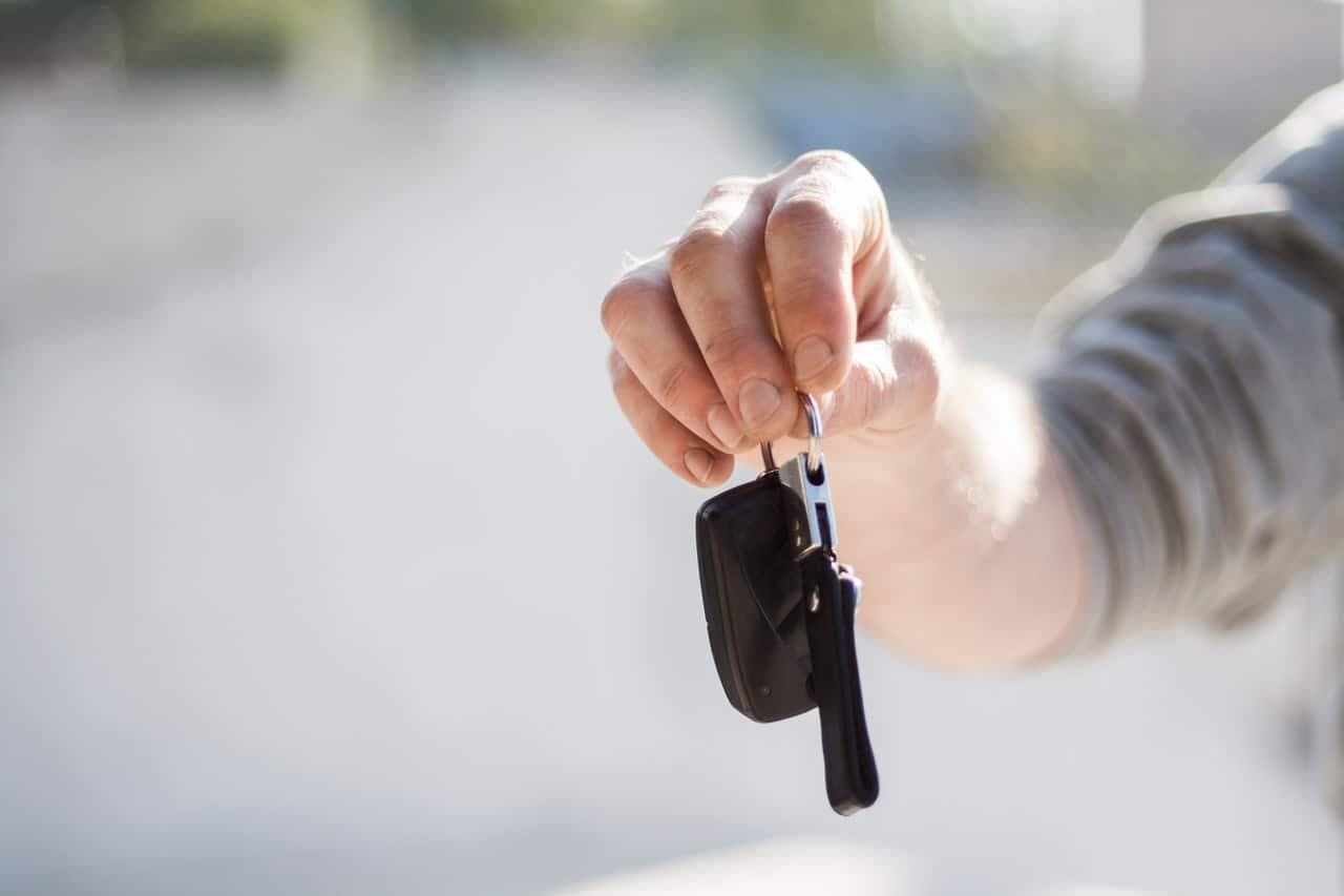 Hand holding car keys in daylight