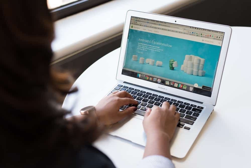Person viewing laptop displaying Android 6.0 Marshmallow interface