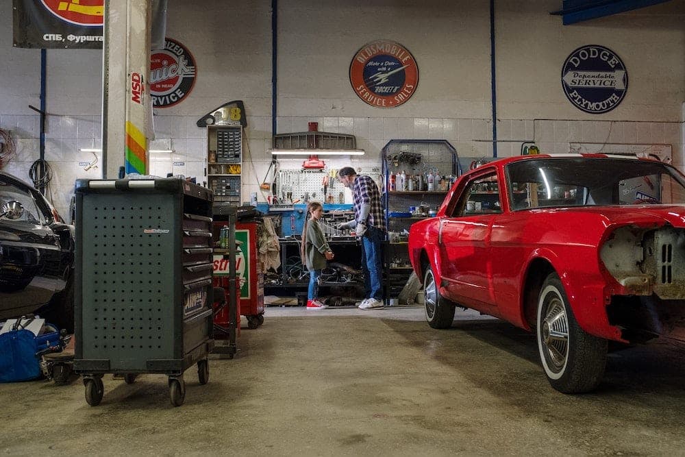 Classic auto repair shop interior with vintage service signs and red car