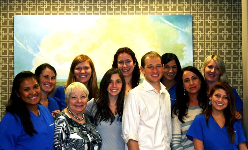 Team of business employees posing together in company branded attire