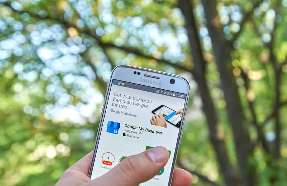 Hand holding phone showing Google My Business app launch screen