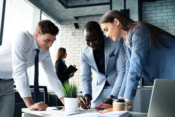 Business team reviewing documents and laptop at office table