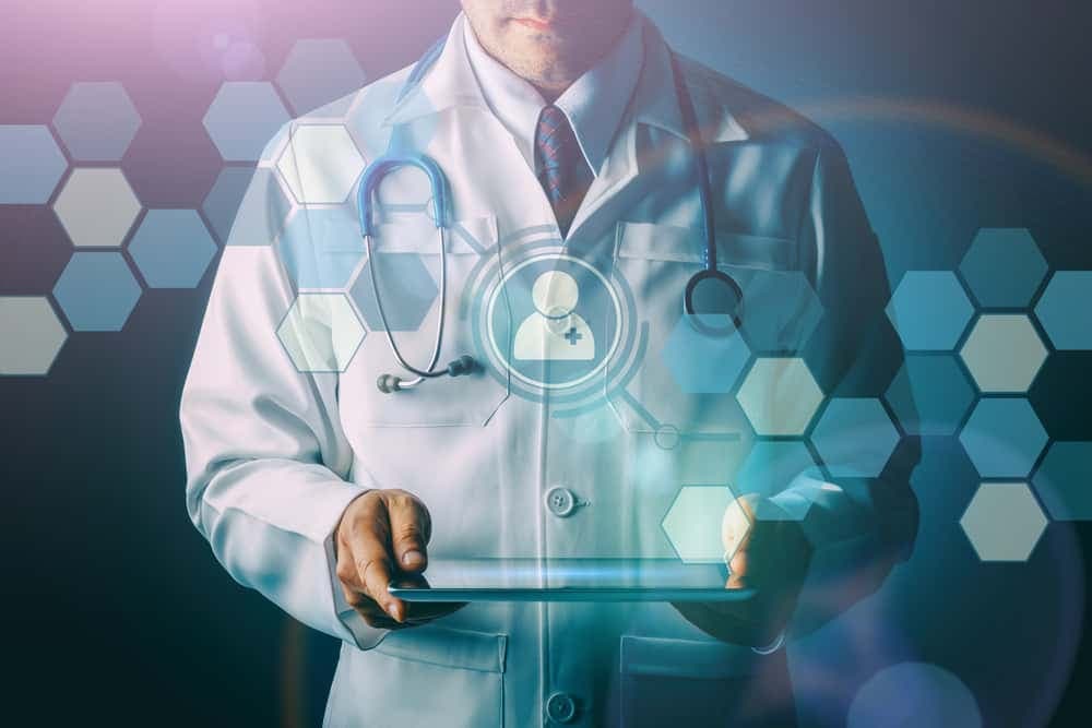 Doctor holding tablet with patient profile icon and medical technology symbols