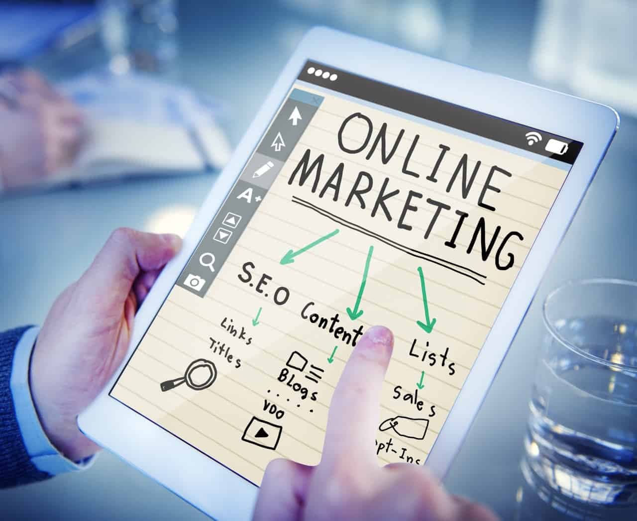 Tablet displaying online marketing diagram showing SEO content, links, titles, video, blogs