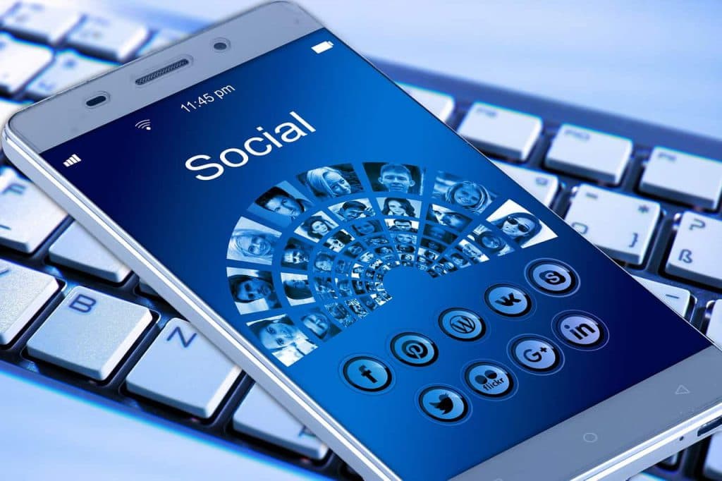 Smartphone displaying social media app with profile pictures and engagement icons