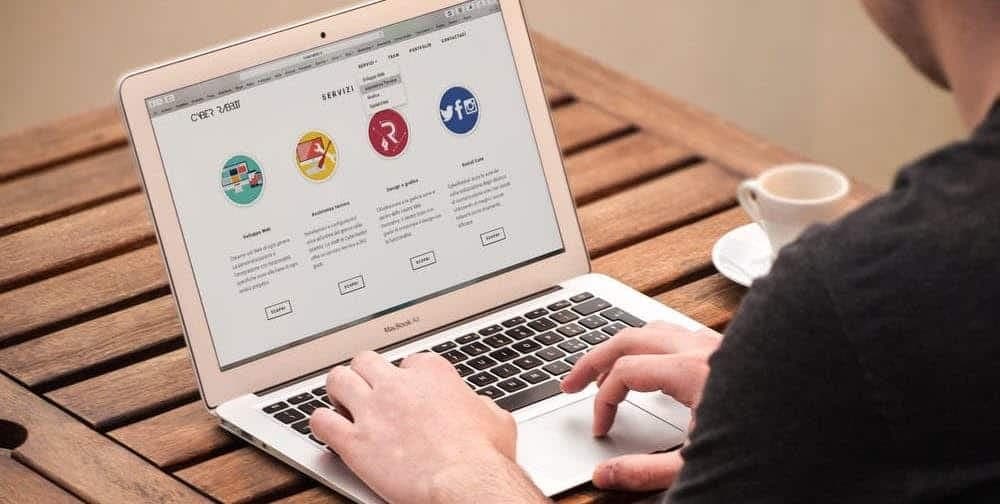 Person using laptop viewing website with colorful service category icons