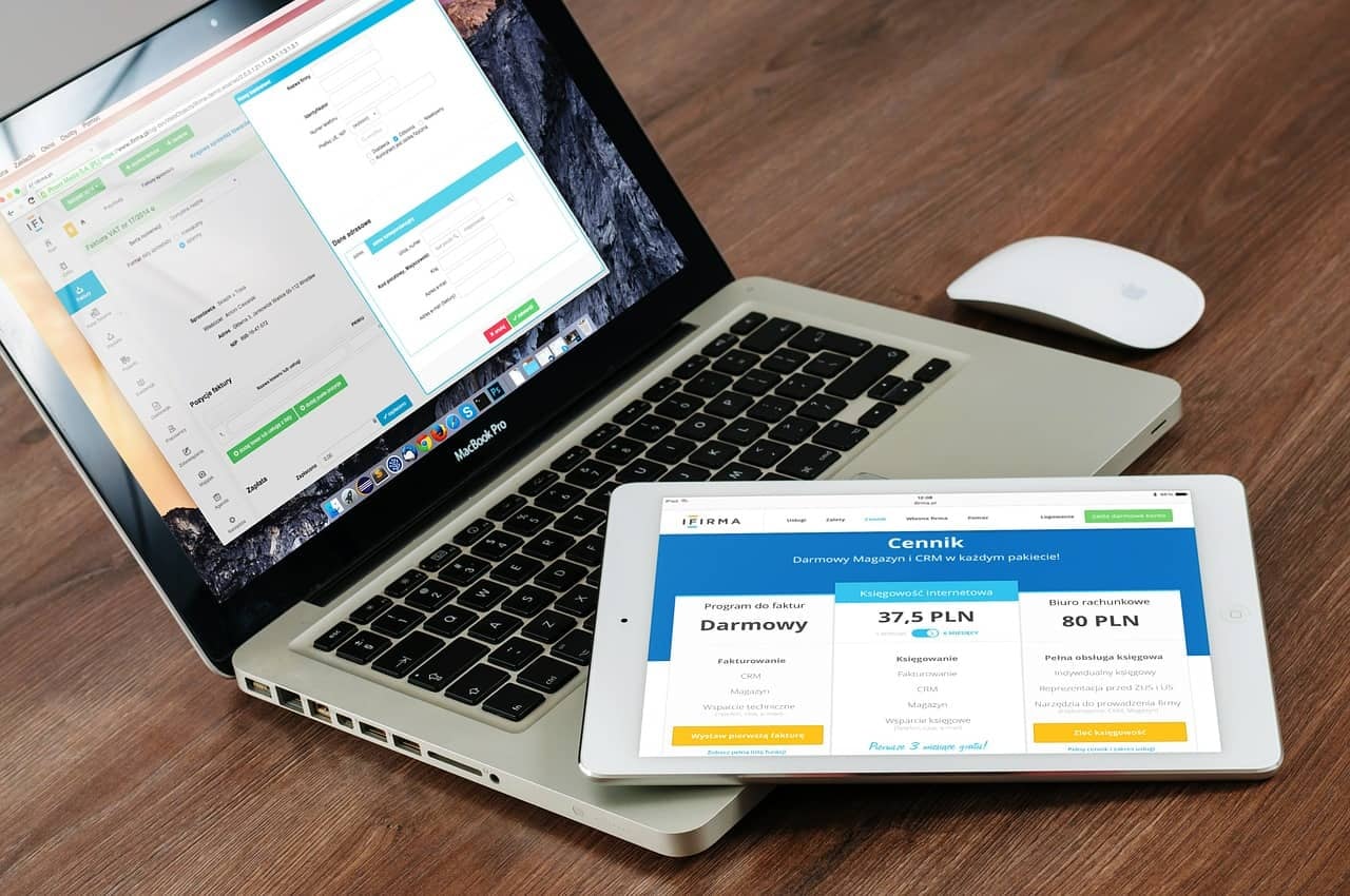 Laptop and tablet displaying Polish business website with pricing tiers and service options