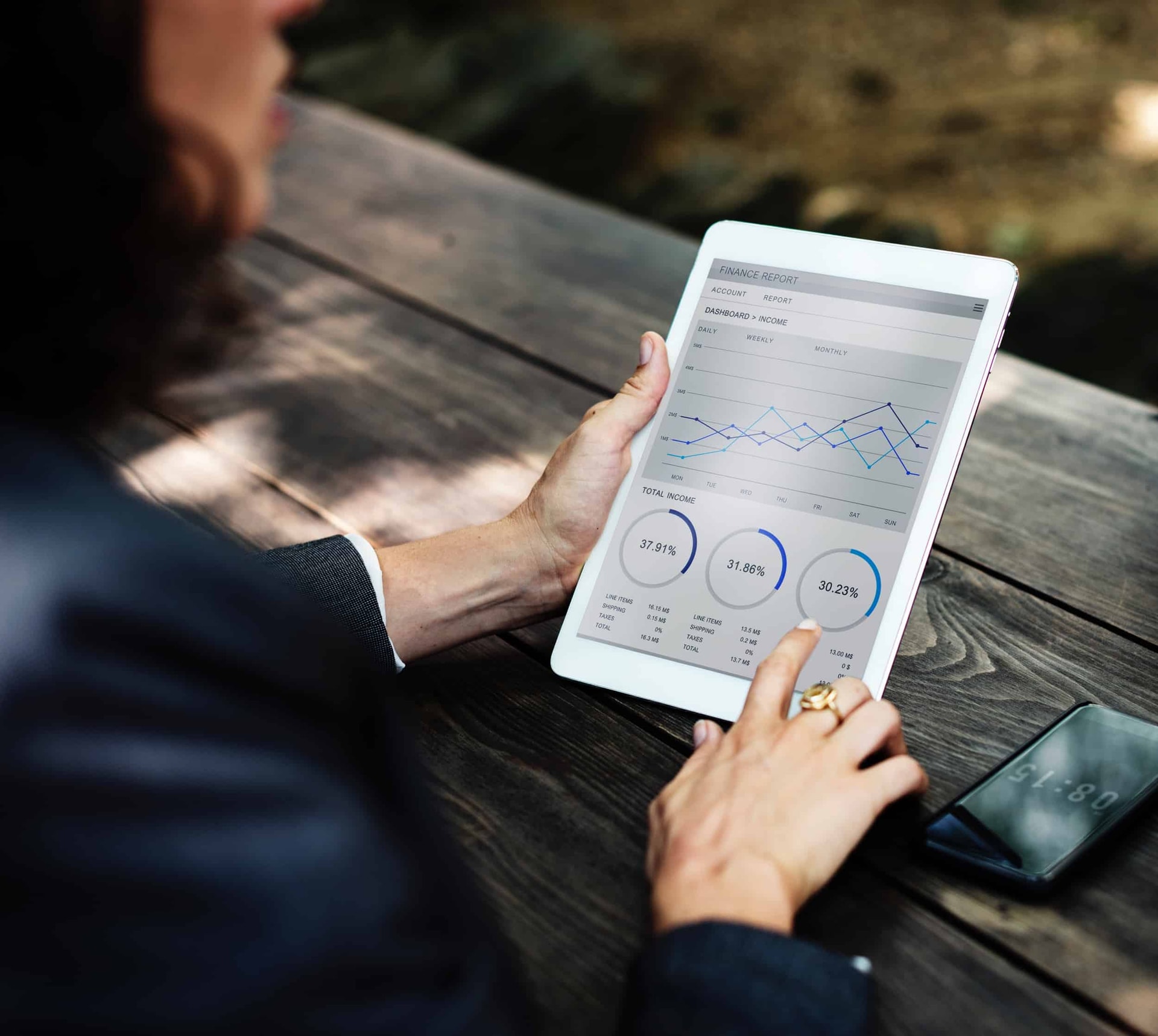 Person viewing finance report on tablet with line chart and percentage metrics
