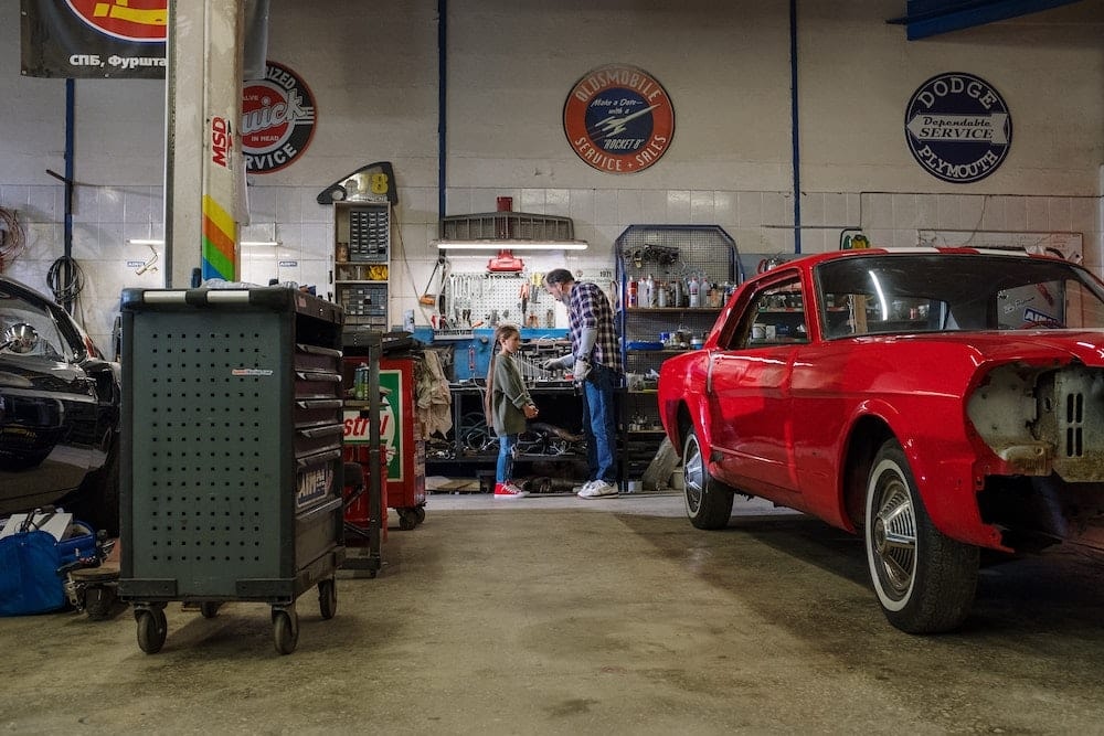 Classic auto repair shop interior with vintage service signs and red car