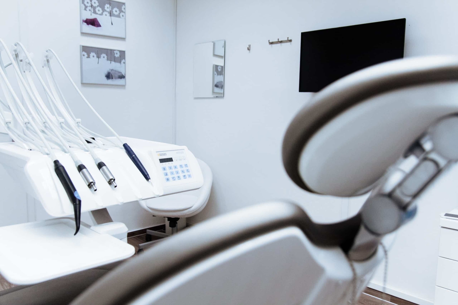 Modern dental office interior with chair, sterilization equipment, and wall photos