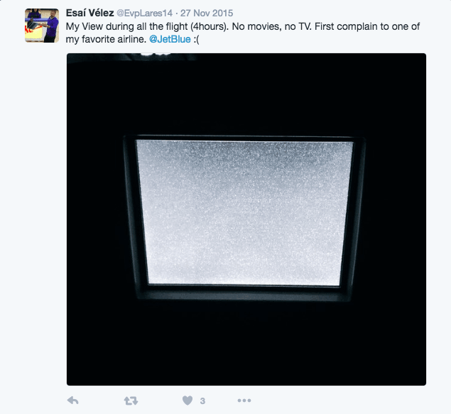 Tweet complaining about a blank, static airplane TV screen, tagged to JetBlue Airways
