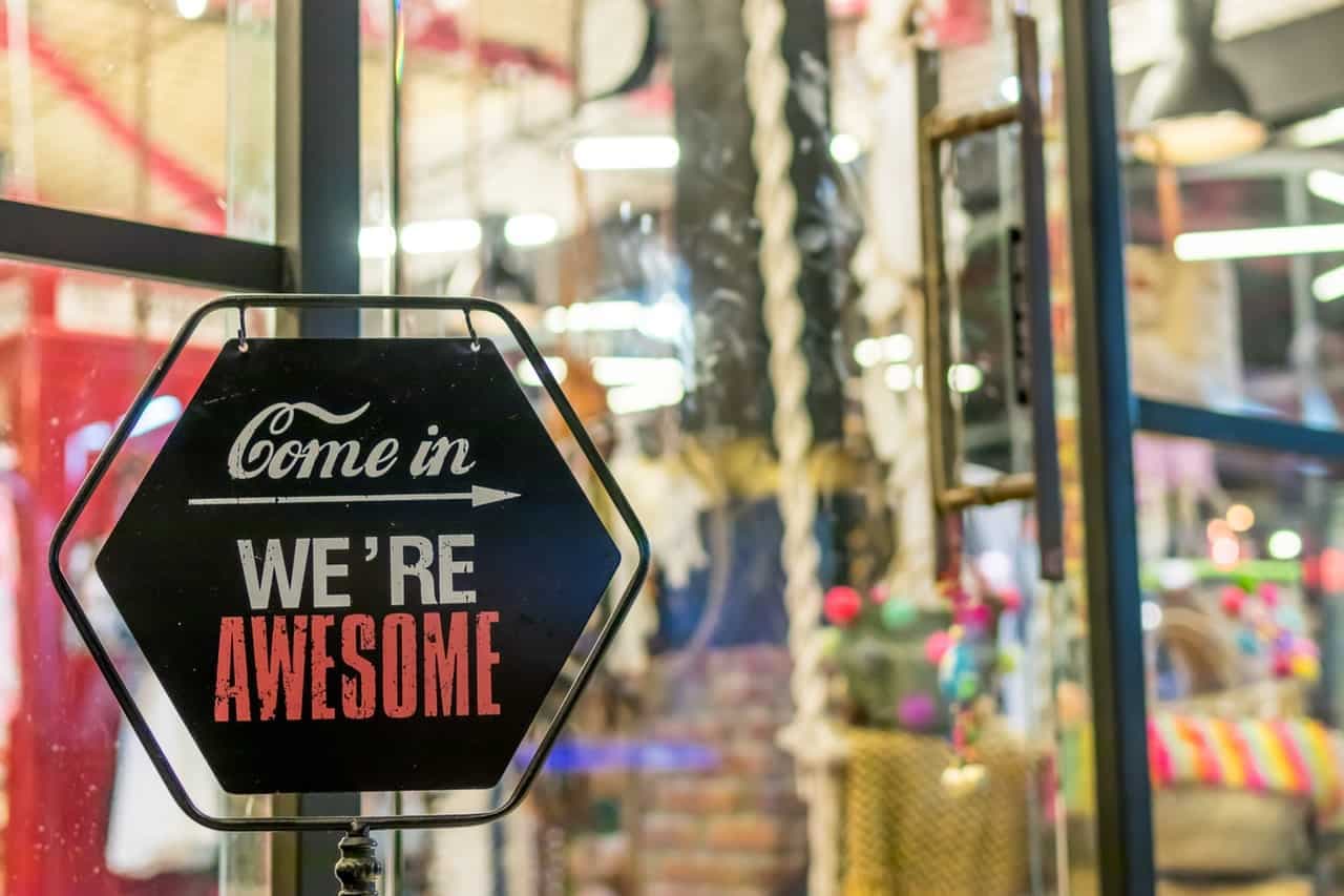 Store entrance sign reading Come in We're Awesome