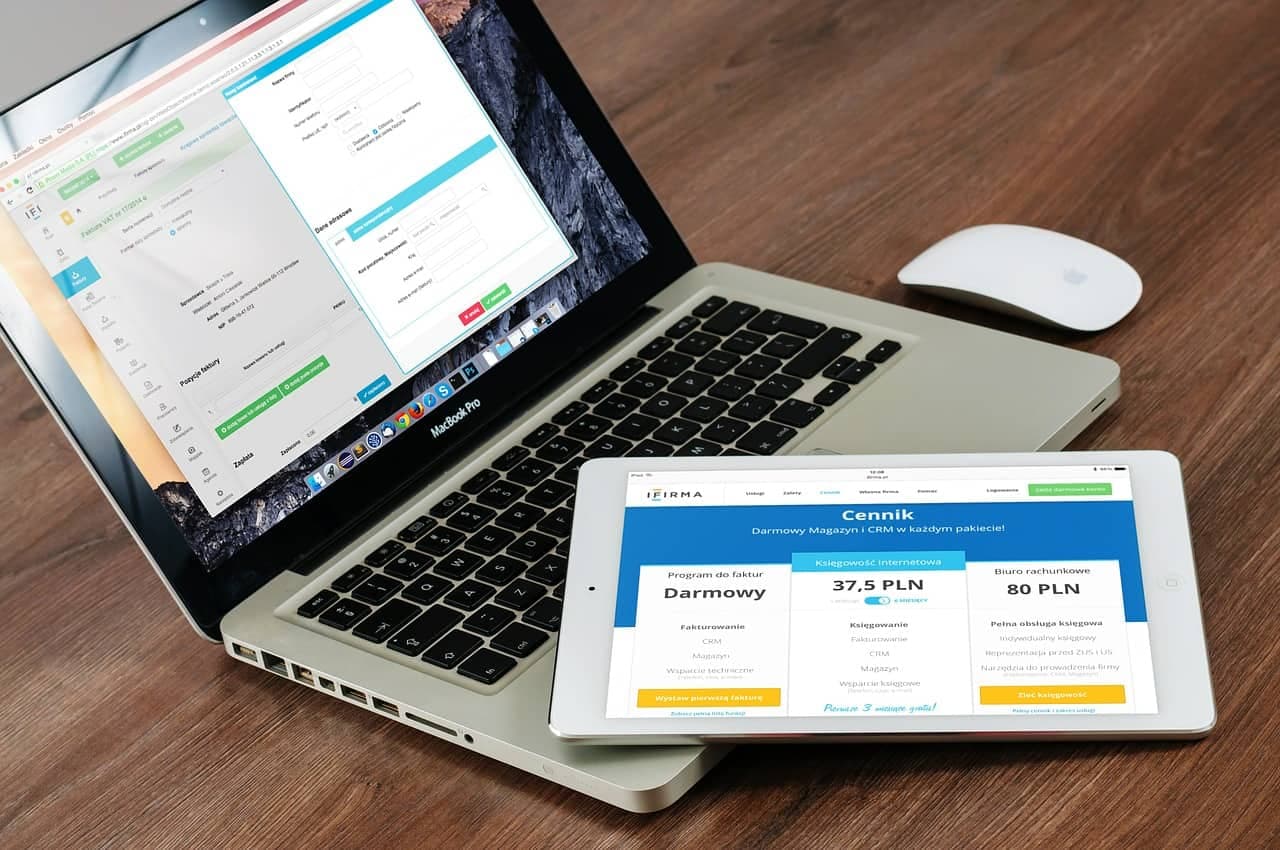 Laptop and tablet displaying Polish business website with pricing tiers and service options