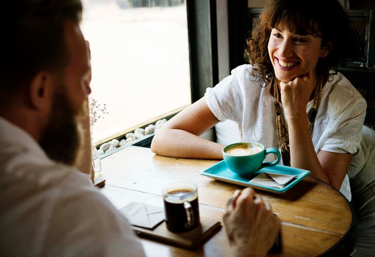 Two people engaged in conversation over coffee at cafe