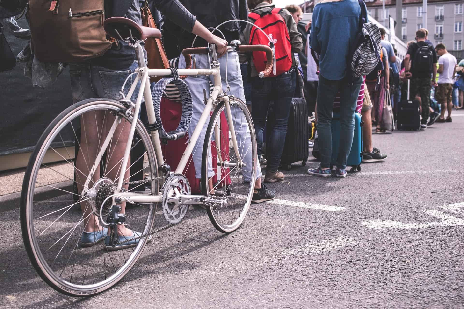 Group of people standing in line on street with bicycles