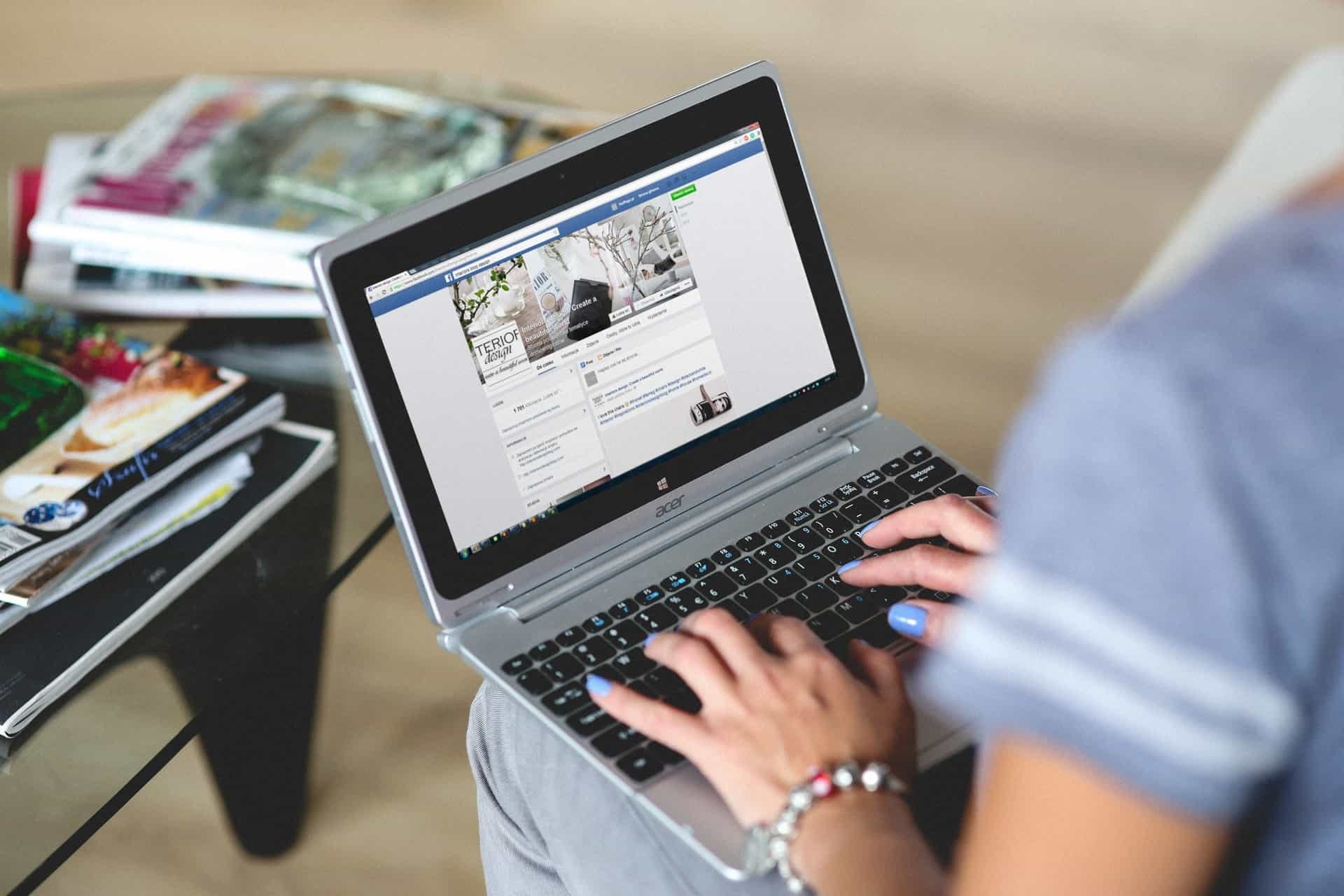 Woman using laptop to manage Facebook business page