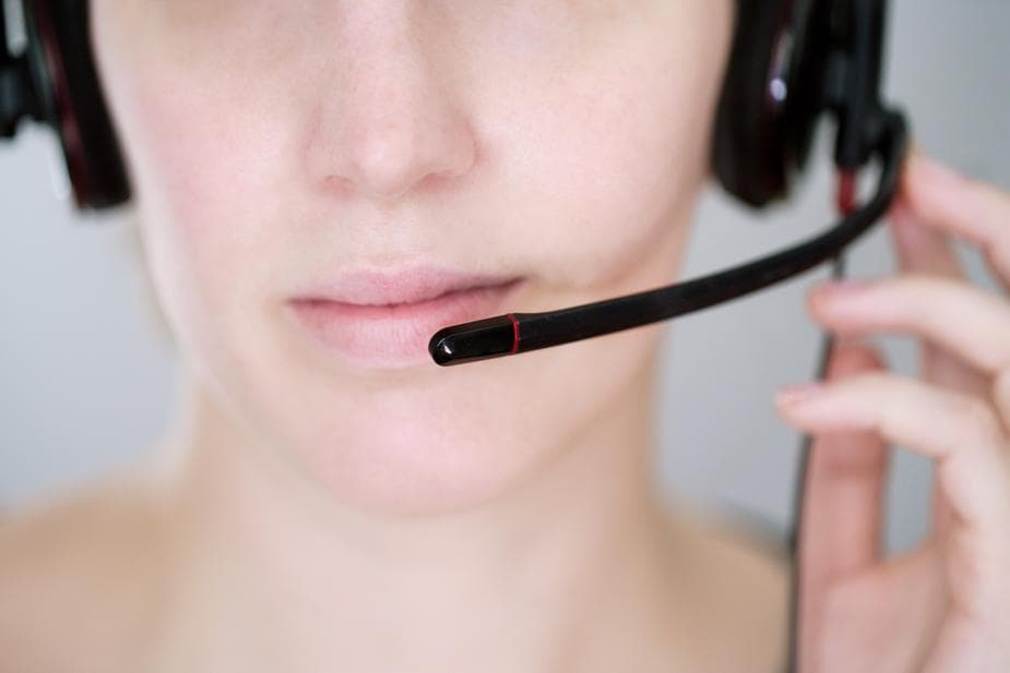 Close-up of customer service representative's face wearing headset microphone in professional setting