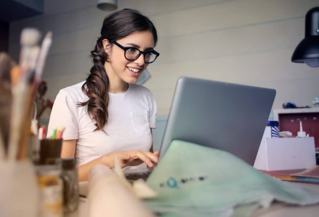 Woman smiling while working at laptop in bright office