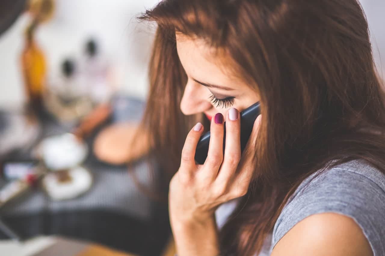 Woman speaking on phone call with blurred office background